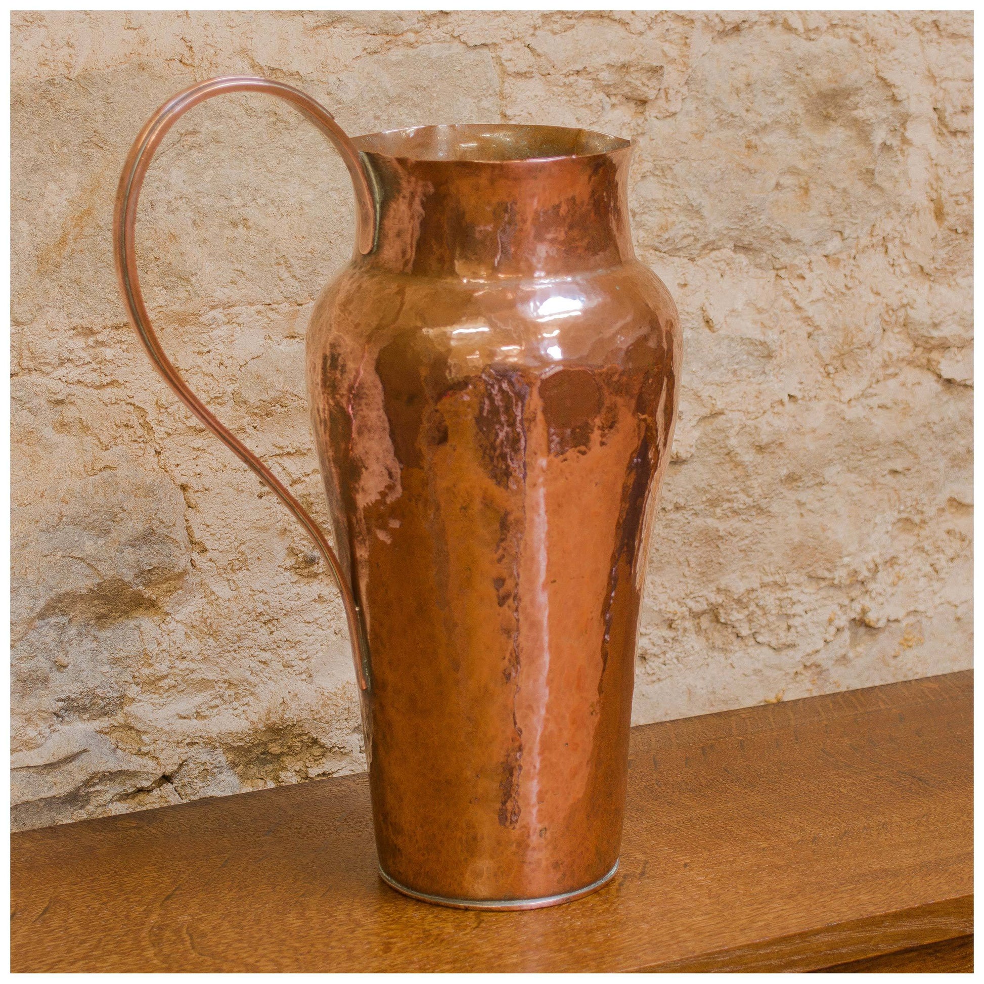 An Arts & Crafts Lakes School hand beaten copper jug by Fanny Carter